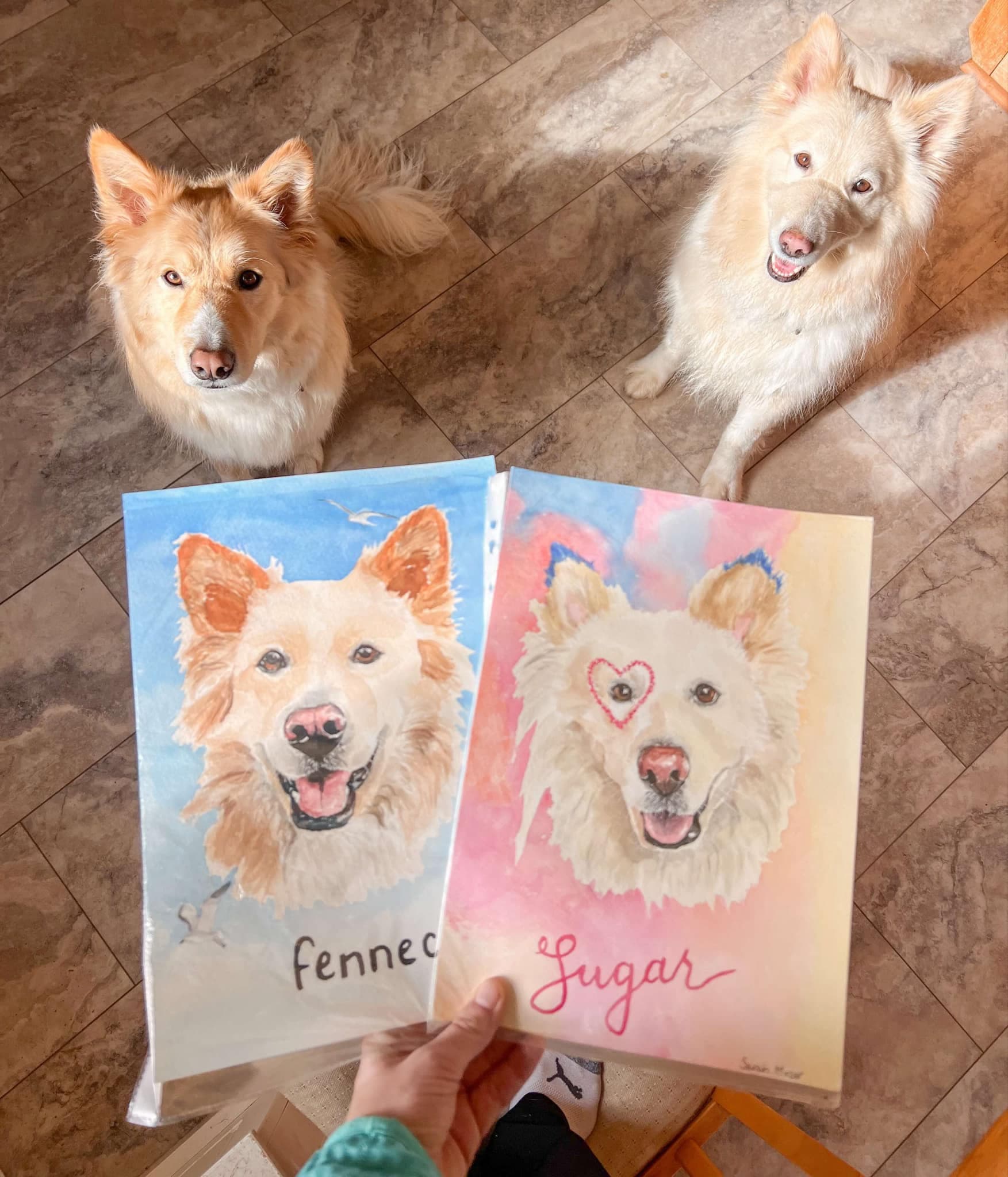 Two hand-painted dog portrait cards held in hand